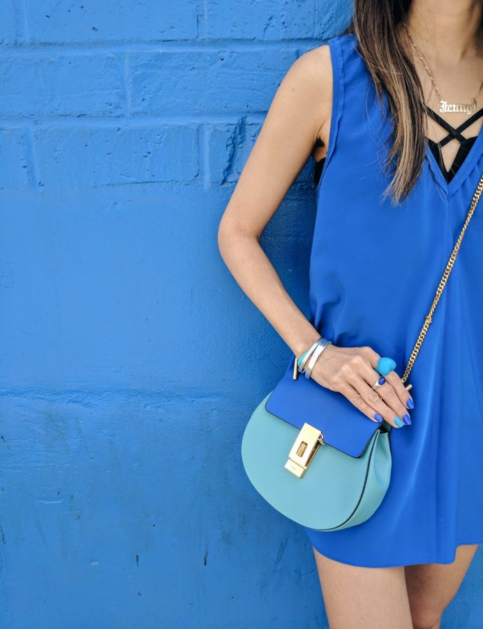 girl with blue chloe drew bag in front of blue wall