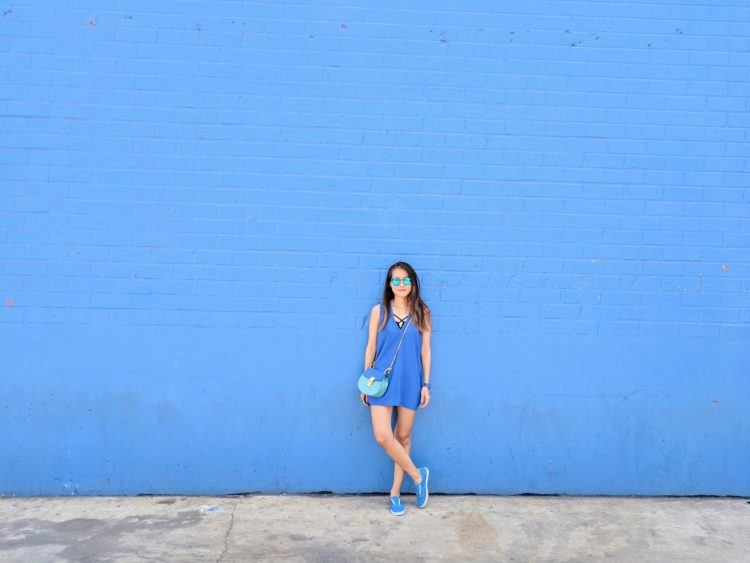 girl in blue standing in front of blue wall